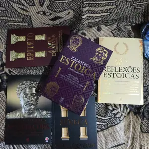 Box e livros da Biblioteca Estoica dispostos sobre tecido estampado