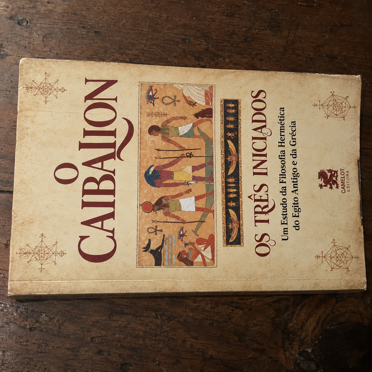 Livro O Caibalion sobre uma mesa de madeira